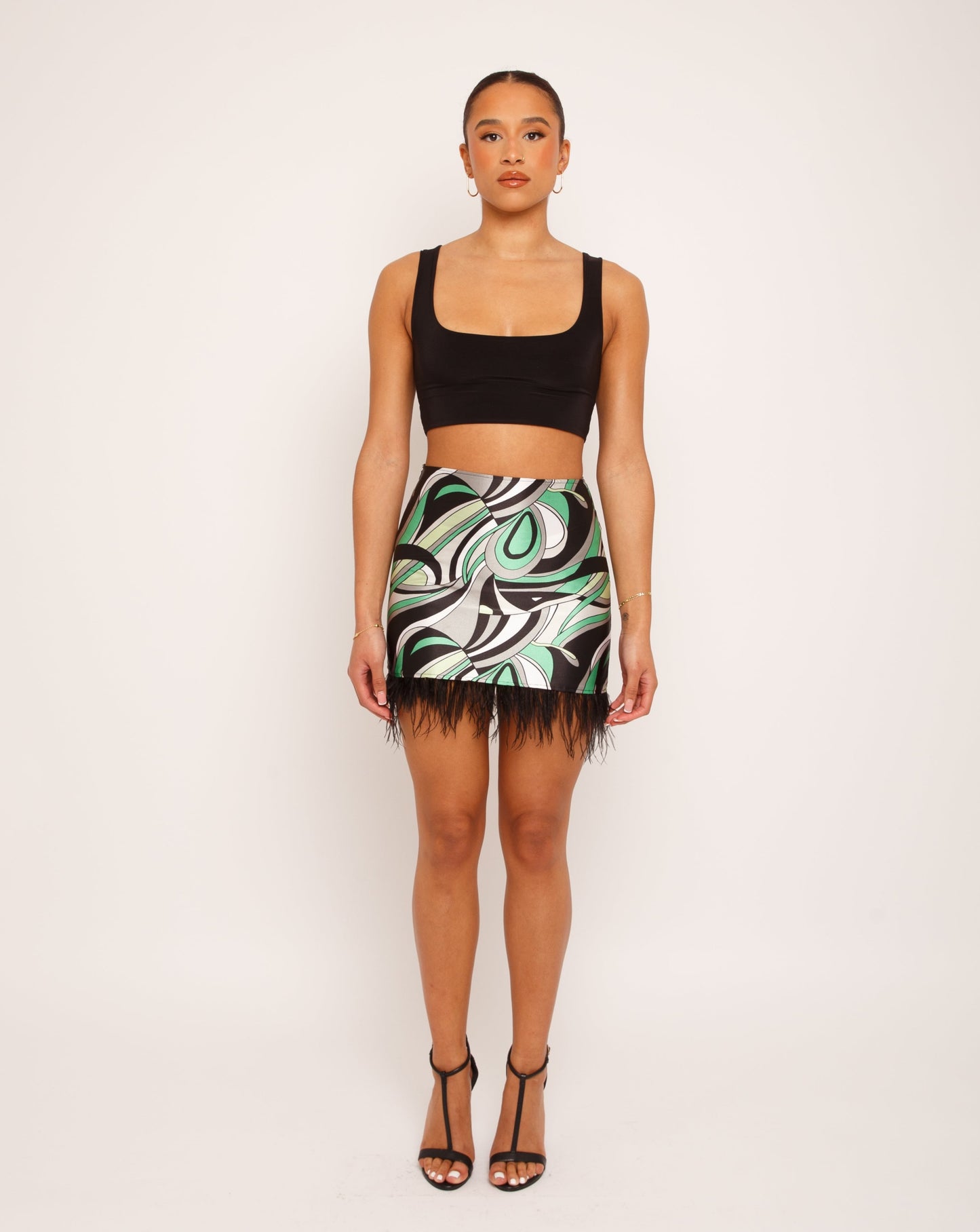 Abstract printed satin mini skirt. Black feather detail